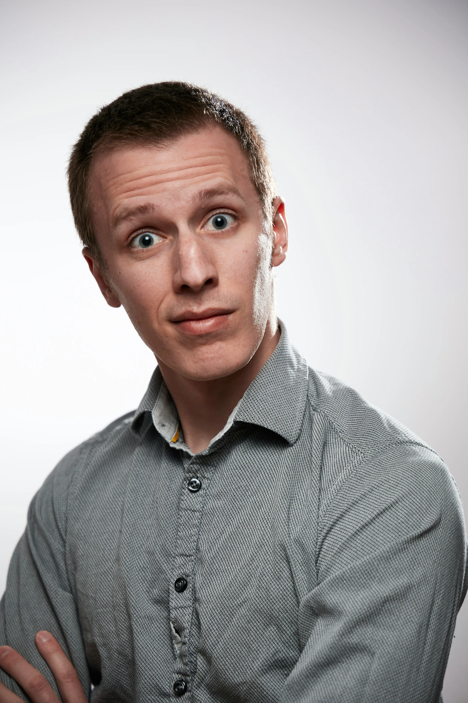 a man posing for the camera while looking off in to the distance