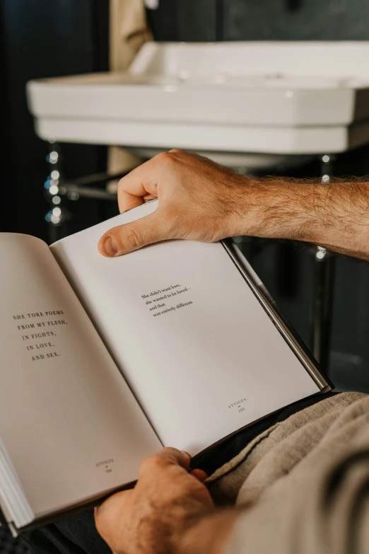 person sitting on the floor holding a book in his hand