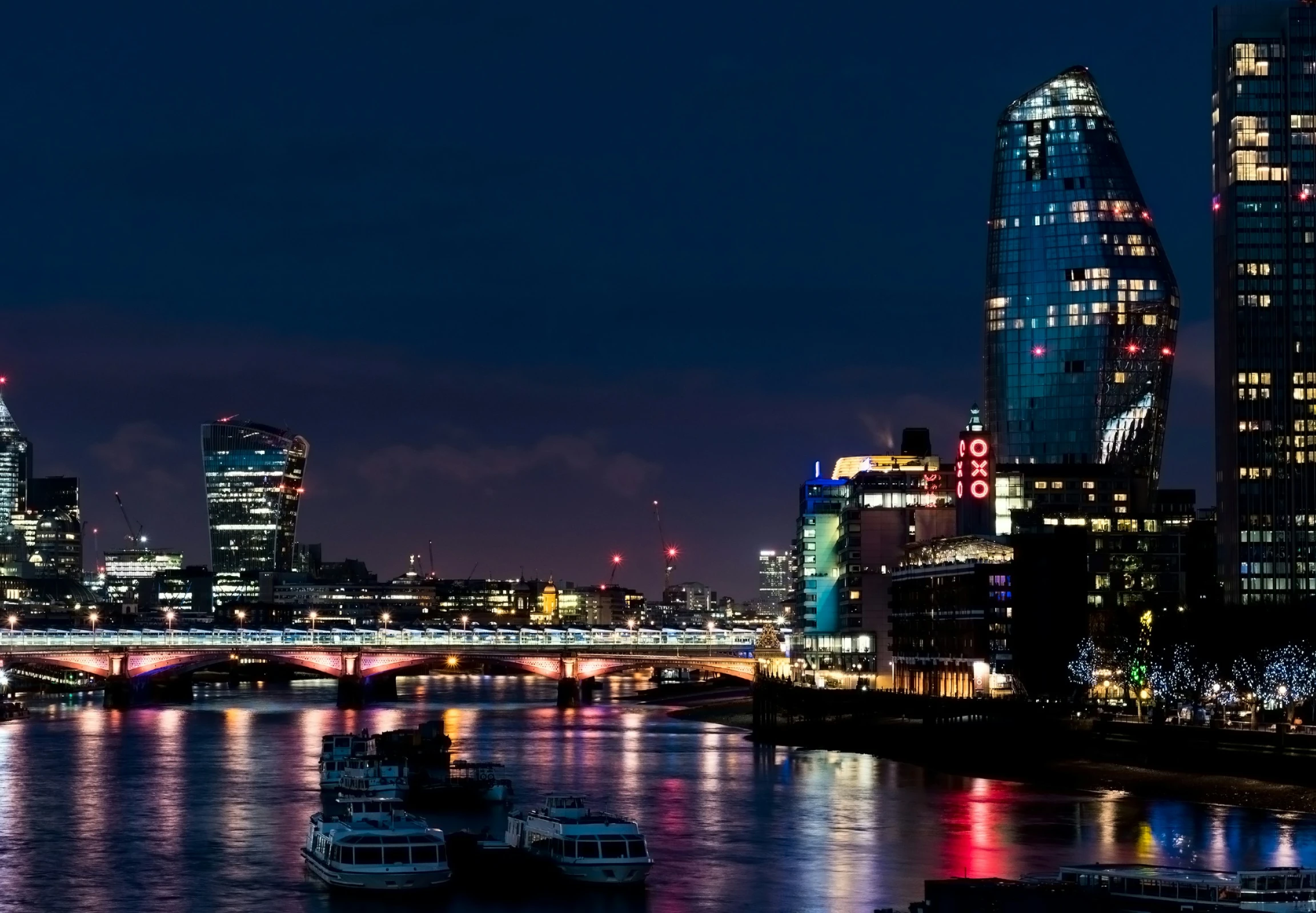 a view of boats floating on a river in front of high rise buildings