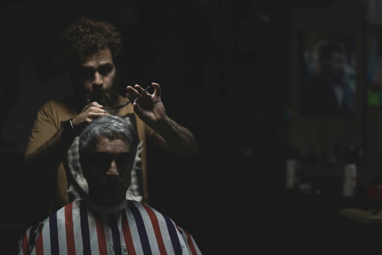 an old man getting his hair trimmed and colored black and white