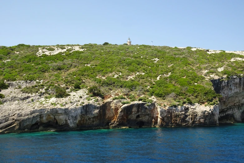 a large body of water sitting below a rocky hillside