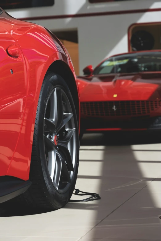 a red sports car and another one is parked next to each other