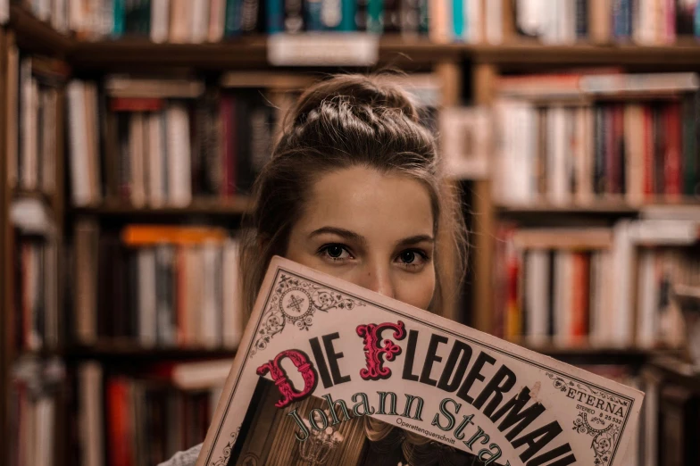 the woman holds a magazine with one side printed