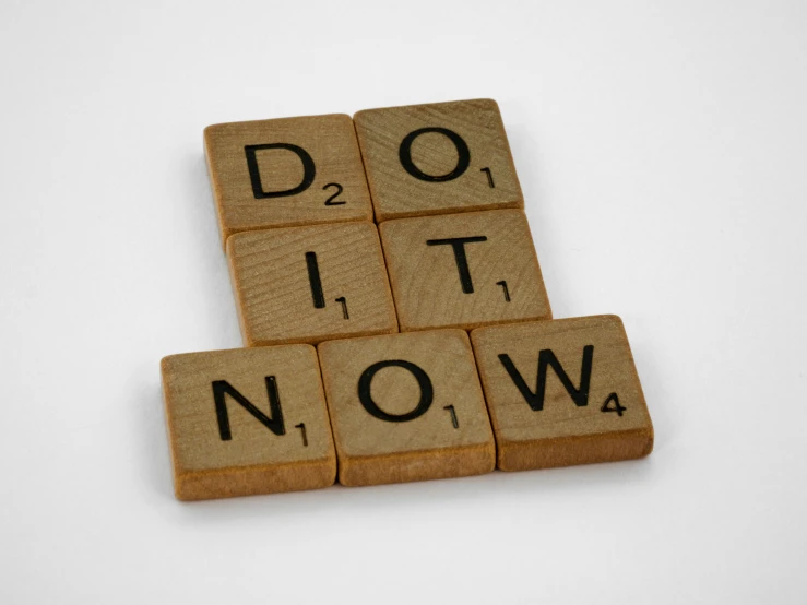 three pieces of scrabble written on wood that say do it now