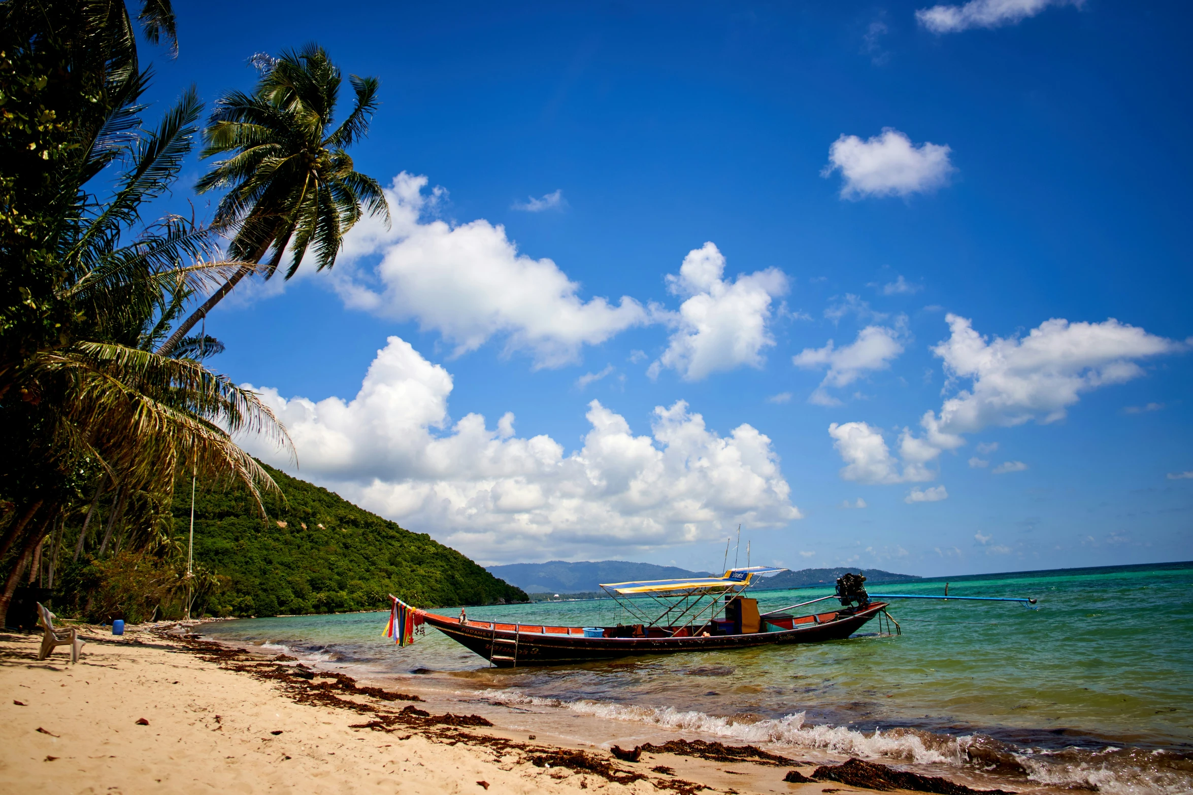 boat near beach in tropical setting with blue sky