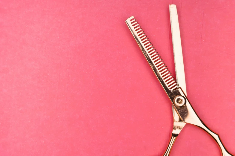 there is a comb and scissors on the pink table