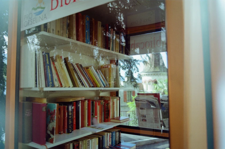 book cases are full of books, some in front of a window