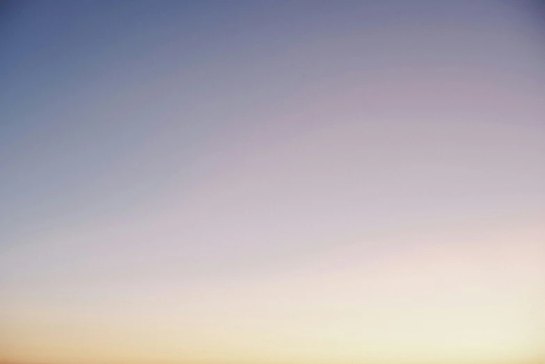 people in water at sunset under an orange and blue sky