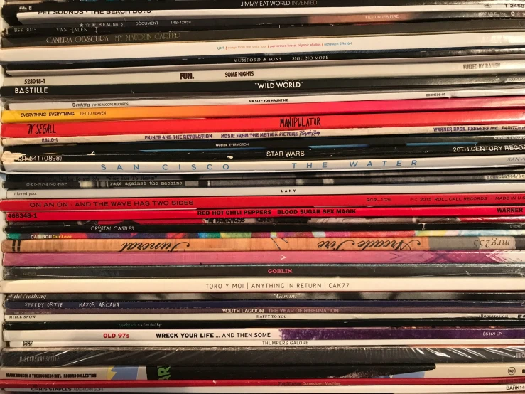 a collection of different records on a wooden rack