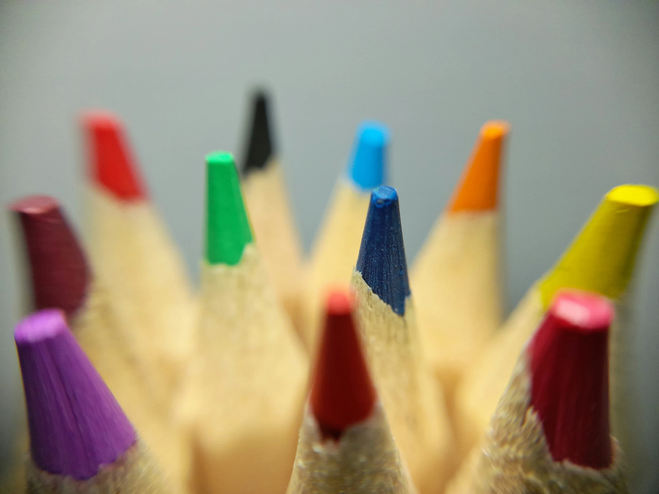 several colored pencils lined up on a table