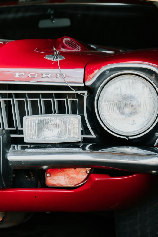 a red vintage car with an grille and headlight