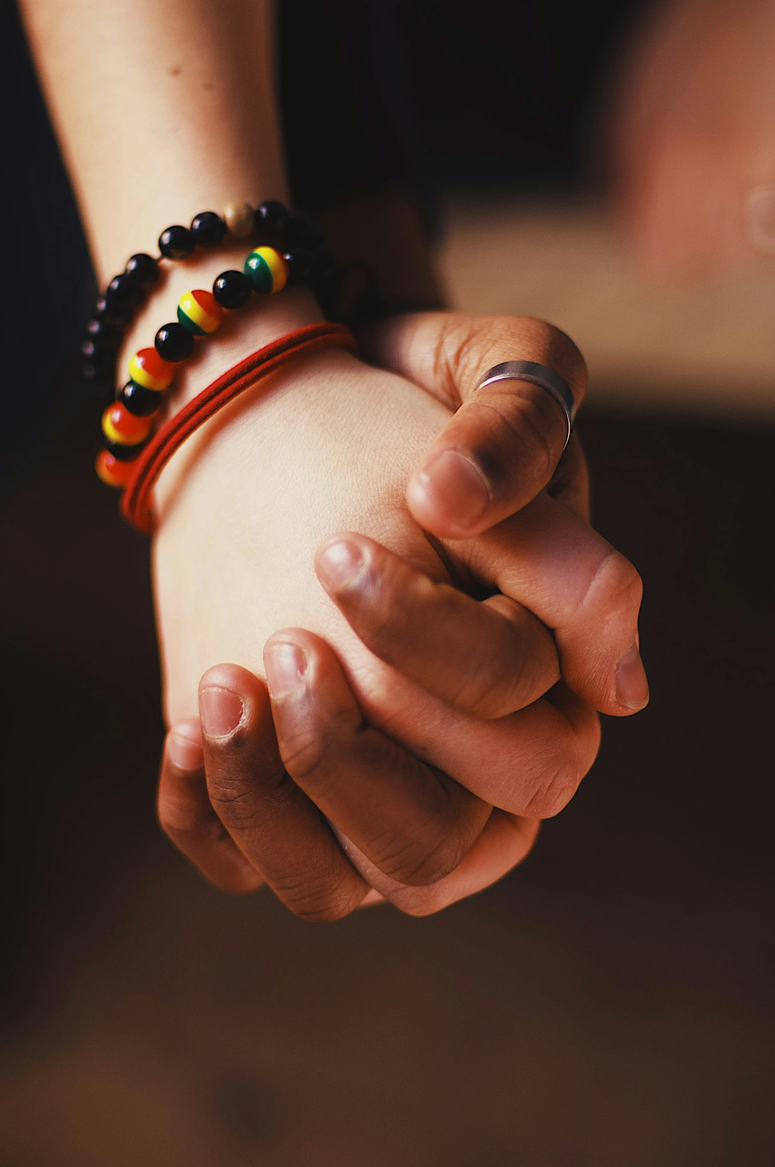 a woman's hand is holding another women hand with three different colored celets