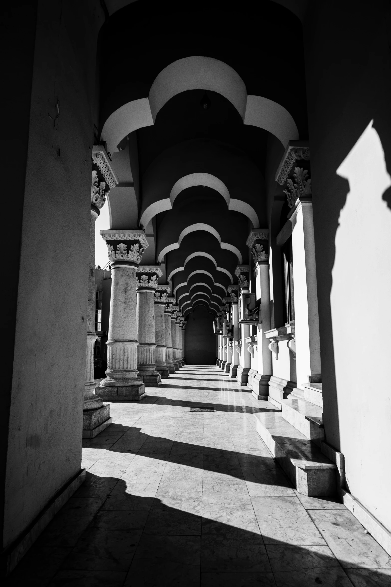 the sun shining through the archways in an empty building