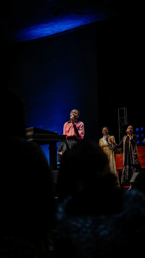 people stand in a dimly lit room in the dark