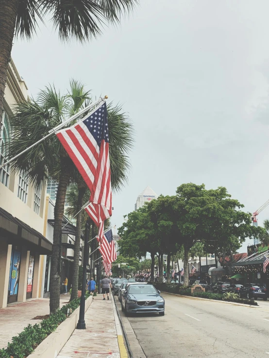 an american flag on a pole on the side of the street