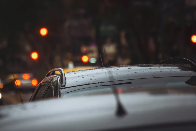 rain drops on the windshield of a car during the night time