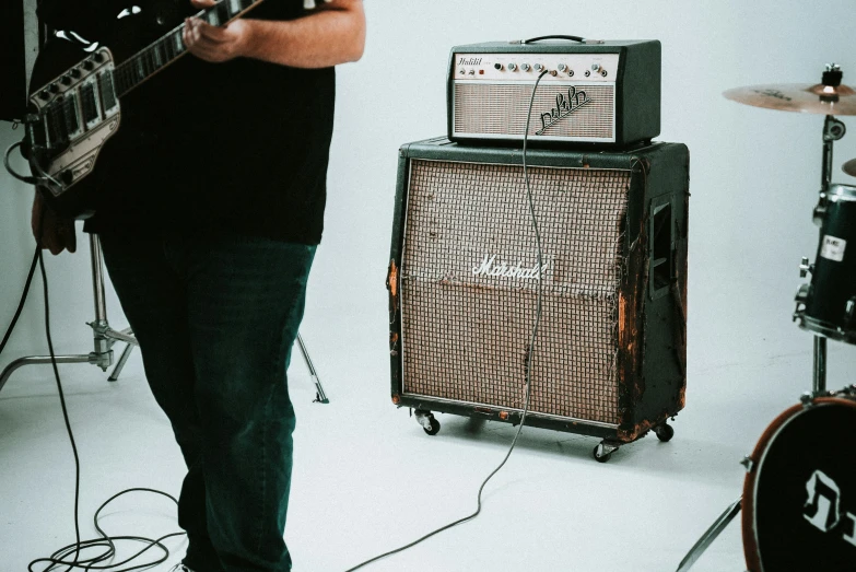 a man standing next to a bunch of guitar equipment