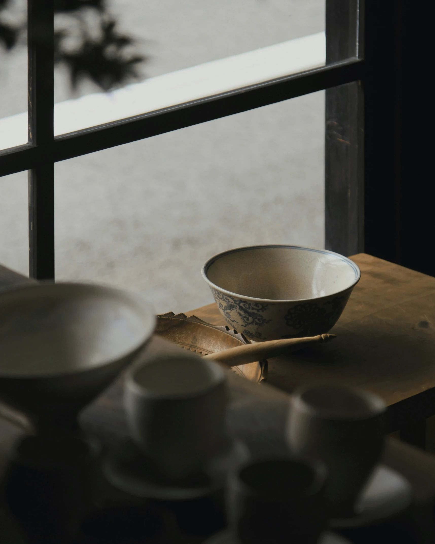 there is a bowl, saucers, and spoon on the table