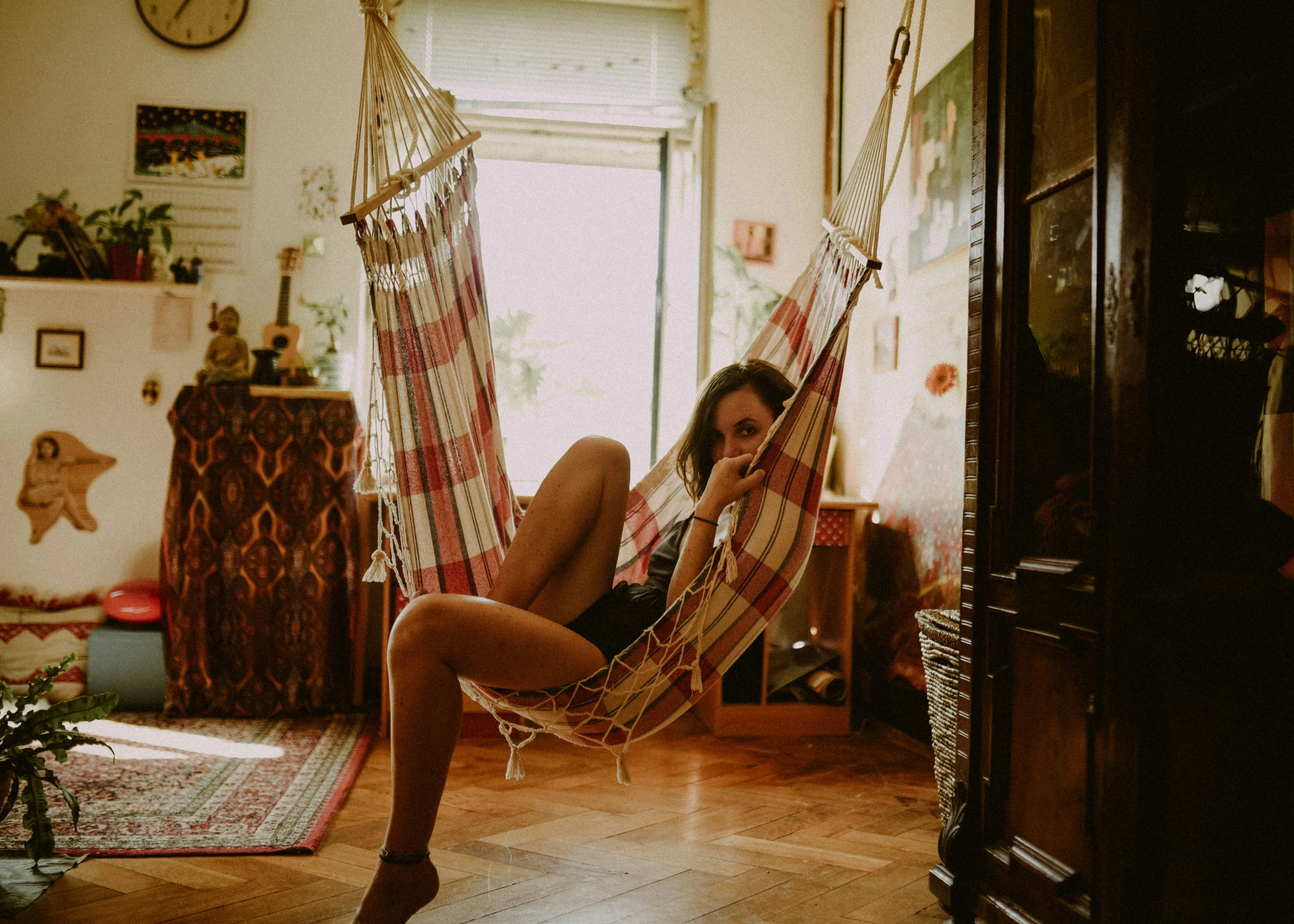 woman in high heels is on a hammock in a room