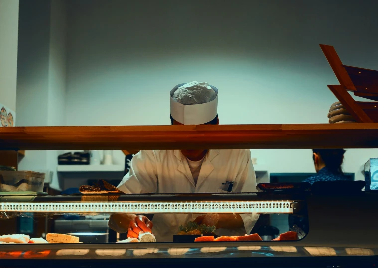 a cook behind counter preparing food for customers