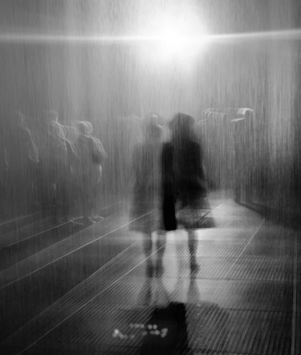 the silhouettes of people walking through a hallway in the rain