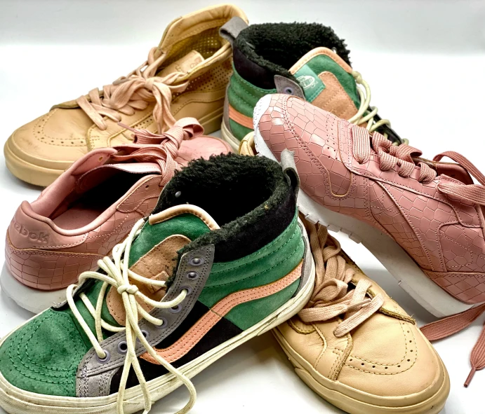 several different colored sneakers on a white surface