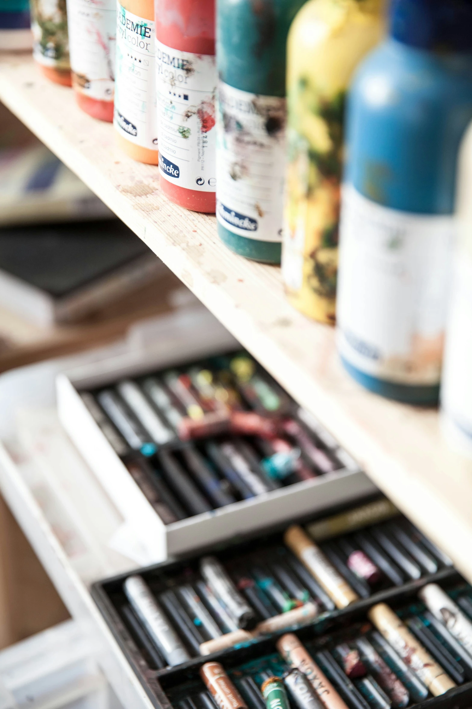 an assortment of markers, pencils and pens are on a shelf