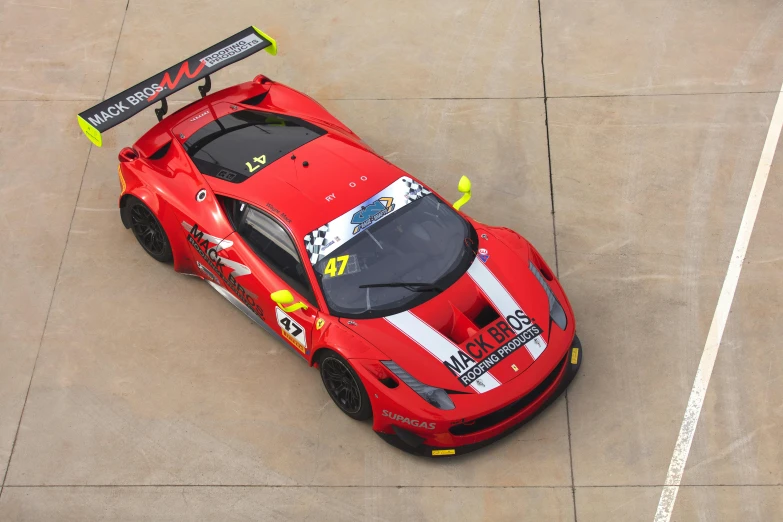 a red race car sitting next to an empty parking lot