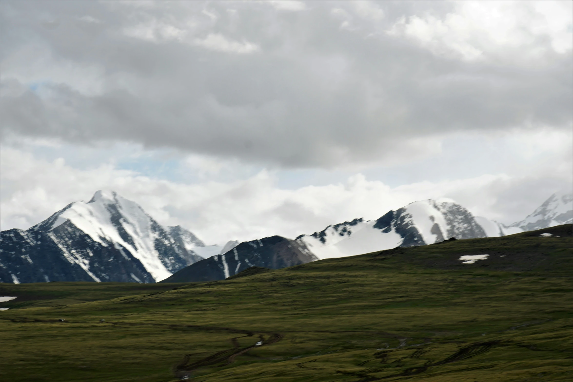 some very large snow covered mountains in the sky