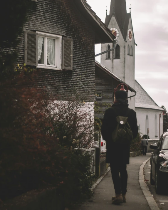 a person walking down the sidewalk near some cars