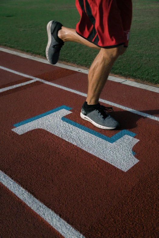 the man is running on the track with his foot