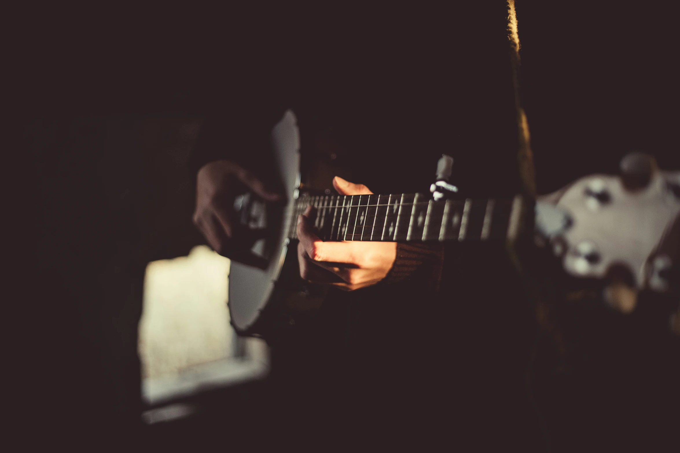 a person is playing the guitar in the dark