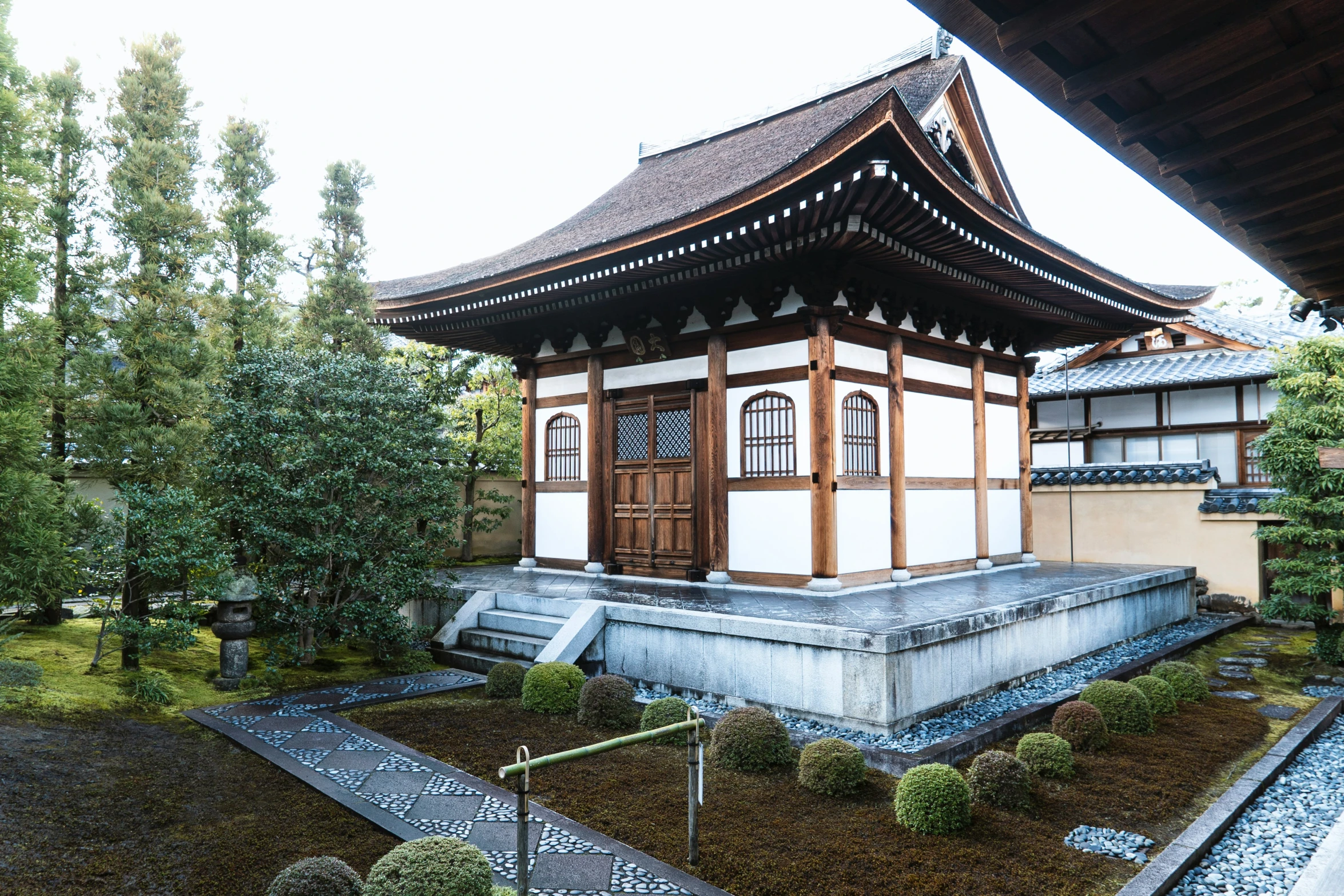 a pagoda sits in the middle of some green plants