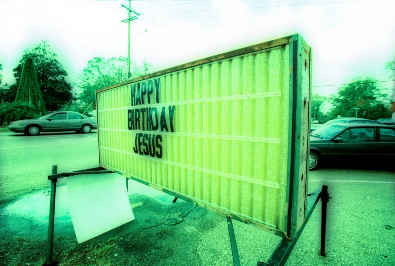 a yellow birthday sign sits in a parking lot
