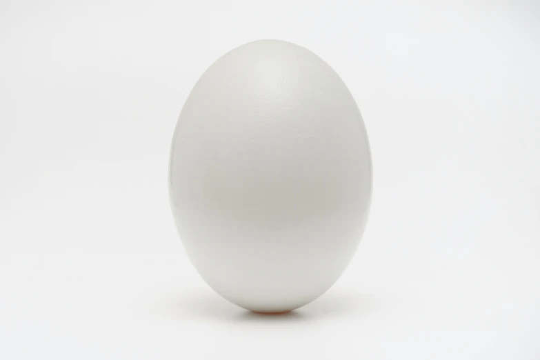 a egg sitting on top of a table next to a white wall