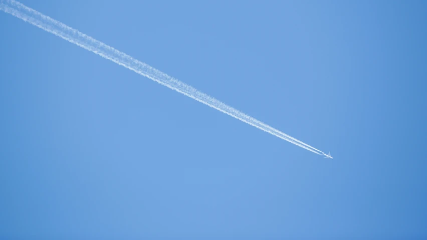 a jet is flying through a blue sky