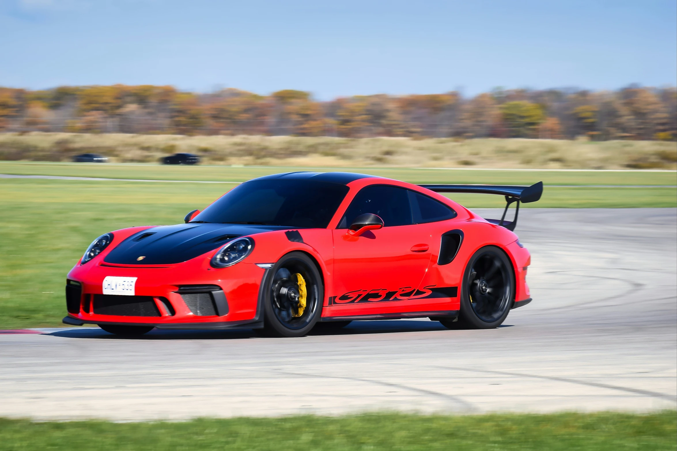 a red and blue sports car driving down a track