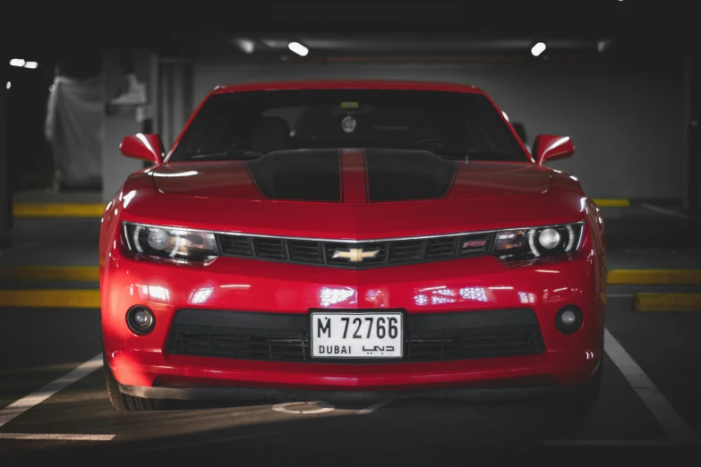 the front of a red car in a parking lot