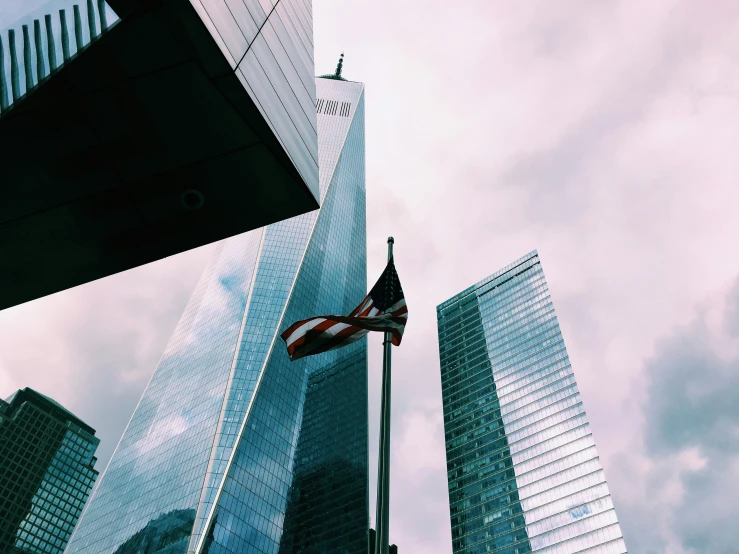 an american flag flying in the wind near skyscrs