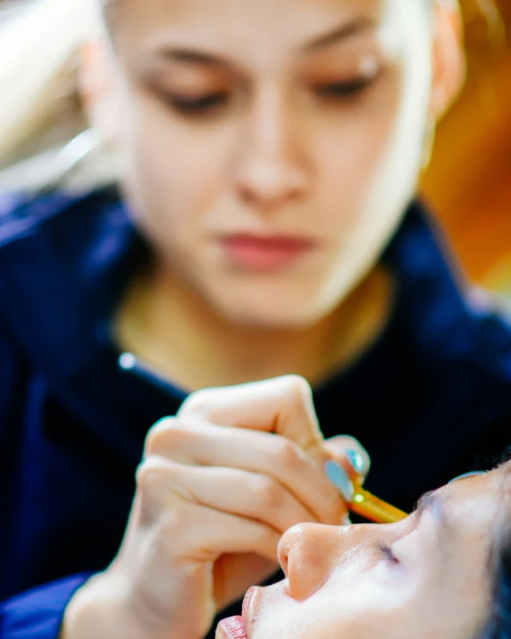 woman getting her nails done with a pencil