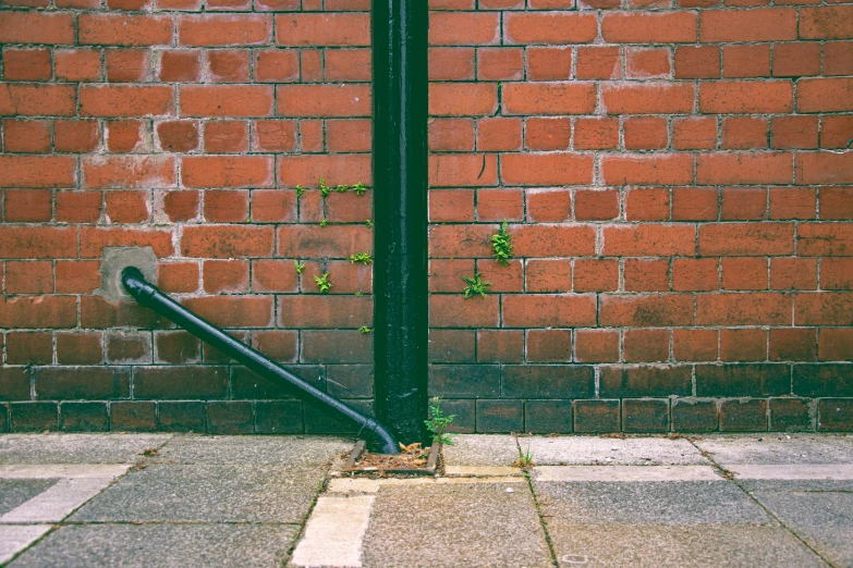 a black pipe against a brick wall