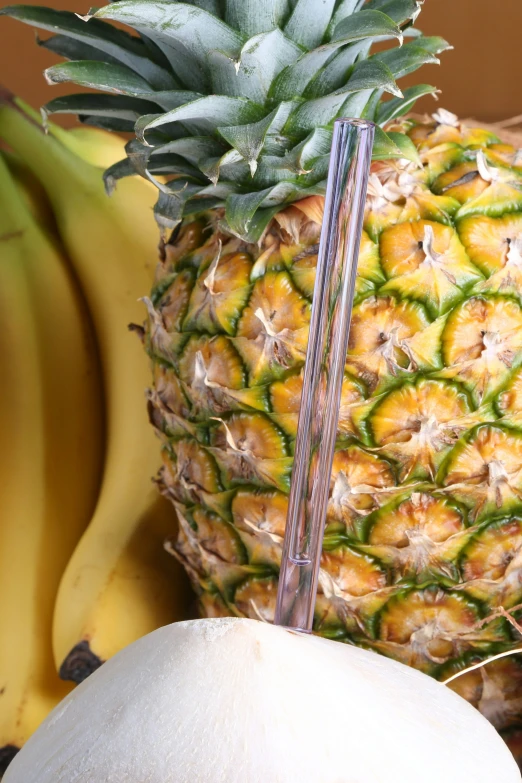 a pineapple and two bananas with a metal straw