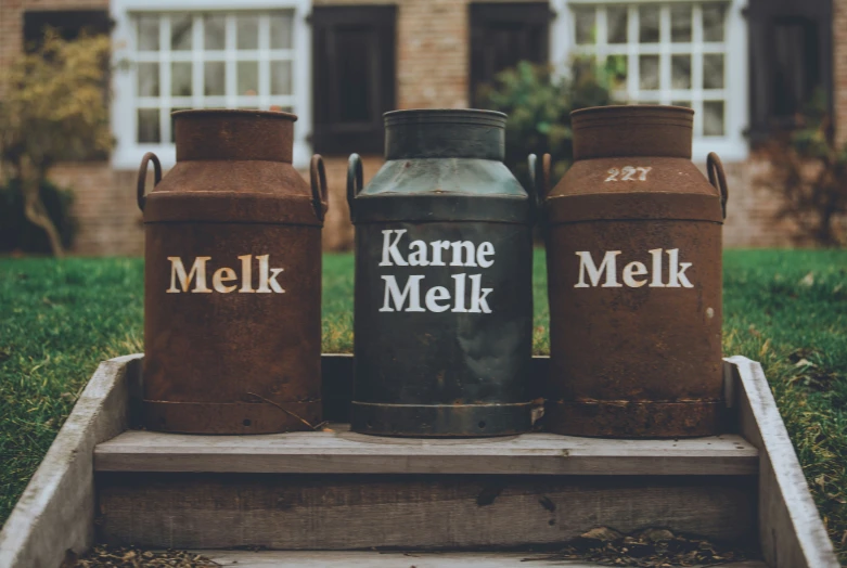 three brown jars are sitting in front of a house