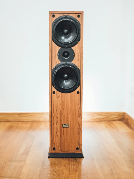 a wooden speaker sitting on top of a hard wood floor