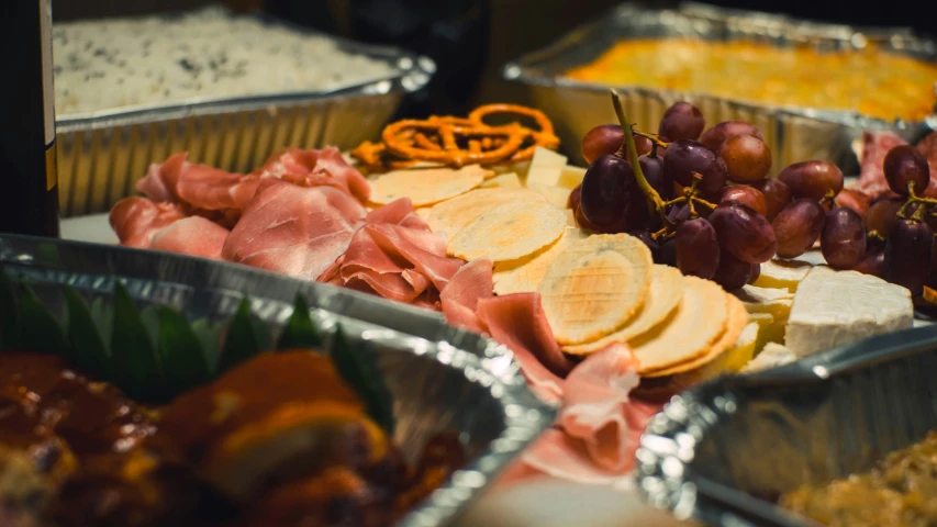 a table of different foods with silver trays on it