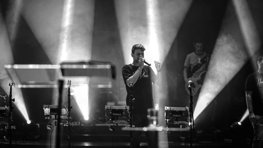 a man standing in front of some microphones on a stage