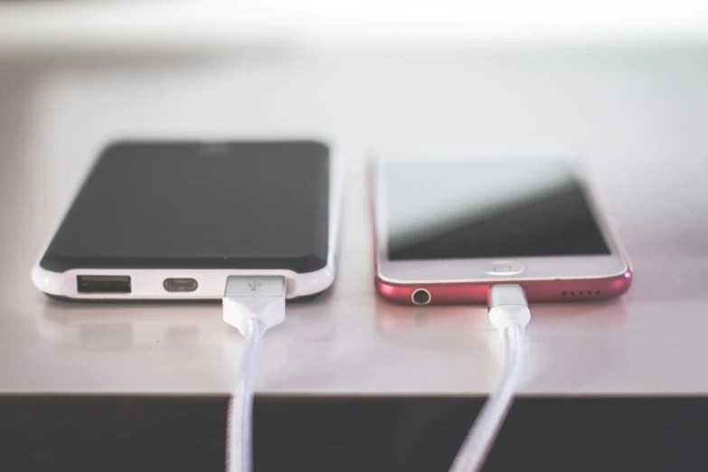 a small cord sits between the two smart phones