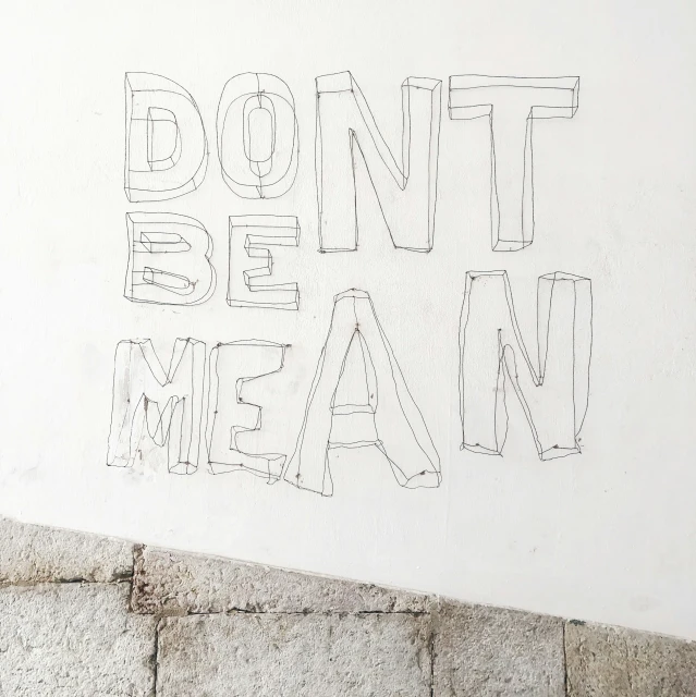 a sign written on the side of a white wall