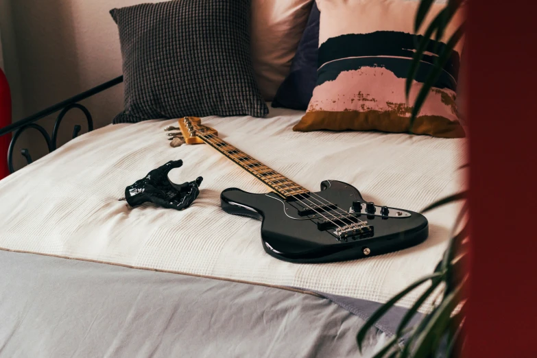 the guitar is laying on the bed with its headphones