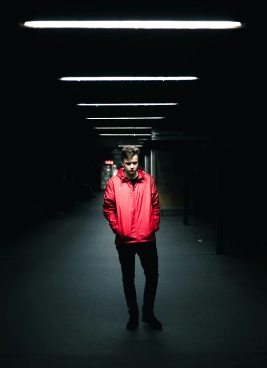 a man is walking towards the camera in a dark hallway